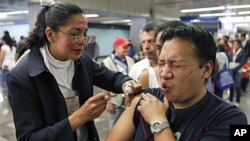 A man is vaccinated against swine flu by a nurse in a subway station in Mexico City. (Jan. 18, 2010)