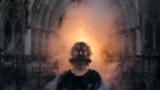 An activist from Ocean Rebellion stands as she wears a scolds bridle medieval torture device, outside the Royal High Court of Justice, in central London, on Jan. 29, 2025. 