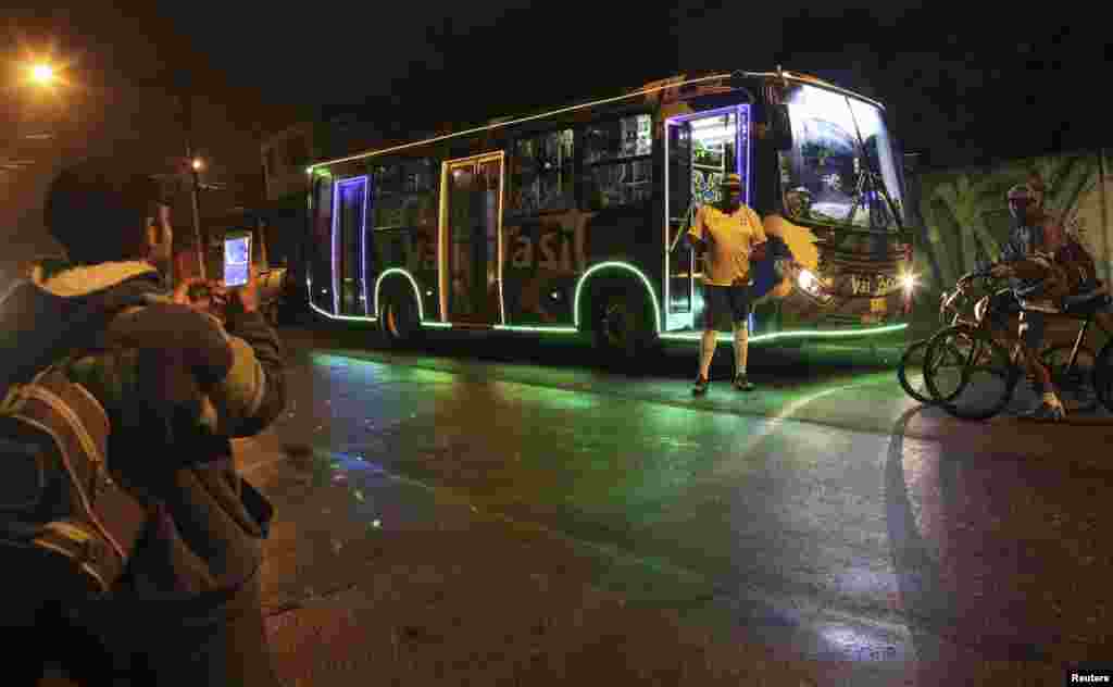 Bus driver Edilson, 45, also known as &quot;Fumassa&quot;, is photographed wearing a Brazil national soccer team jersey outside a city bus decorated with the colors of the Brazilian flag and 2014 World Cup icons, in Santo Andre, on the outskirts of Sao Paulo, June 18, 2014.