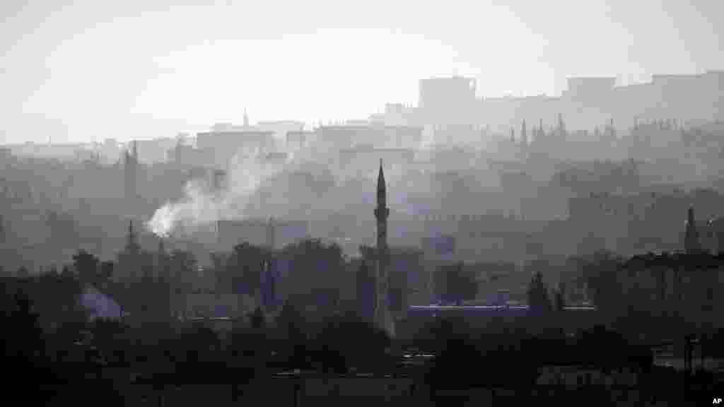 Smoke rises following a strike in Kobani, Syria, during fighting between Syrian Kurds and the militants of Islamic State group, as seen from a hilltop on the outskirts of Suruc, at the Turkey-Syria border, Sunday, Oct. 19, 2014.