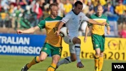 Pemain Australia Vincenzo Grella (kiri) dan bintang tim Amerika, Landon Donovan (kanan) berebut bola dalam pertandingan pemanasan Piala Dunia di Roodenpoort, Johannesburg, Afrika Selatan, Sabtu, 5 Juni 2010. Tim Amerika mengalahkan Australia 3-1.