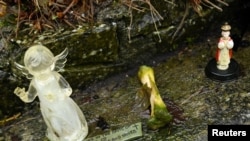 A detail view of a bone and statuettes at a shrine in the Tuam graveyard where the bodies of 796 babies were uncovered at the site of a former Catholic Church-run Bon Secours Mother and Baby Home, in Tuam, Ireland, Jan. 12, 2021.