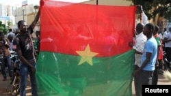 Anti-coup protesters hold Burkina Faso flag in Ouagadougou, Sept. 22, 2015.