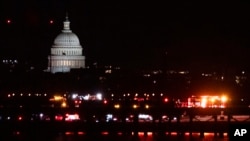 Emergency vehicles stage at Ronald Reagan Washington National Airport, Jan. 29, 2025, in Arlington, Va. The US Capitol is seen across the Potomac River in Washington.