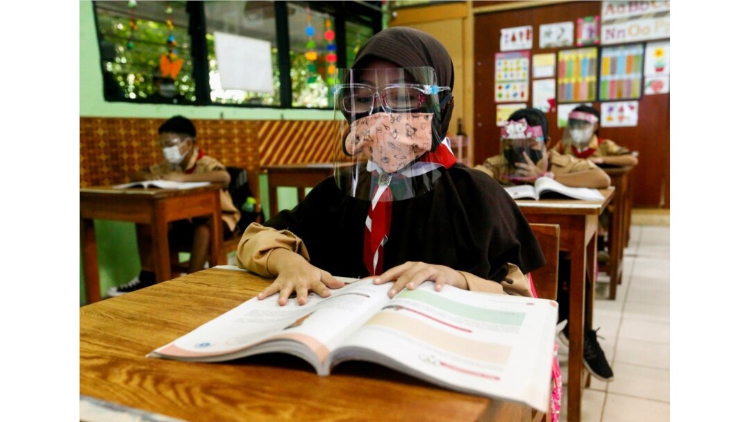 Siswa sekolah dasar yang mengenakan masker dan pelindung wajah menghadiri kelas, saat sekolah dibuka kembali di tengah pandemi penyakit virus corona (COVID-19), di Jakarta, 7 April 2021. (Foto: Reuters)