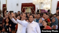 Presiden Joko Widodo dan Prabowo Subianto berswafoto bersama para wartawan di istana kepresidenan, 11 Oktober 2019. (Foto: presidenri.go.id)