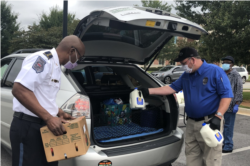 In Douglasville, Georgia outside Atlanta, police officers place groceries into vehicles at a mobile food pantry event. (Atlanta Community Food Bank)