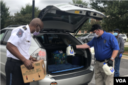 In Douglasville, Georgia outside Atlanta, police officers place groceries into vehicles at a mobile food pantry event. (Atlanta Community Food Bank)