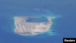 FILE PHOTO - Chinese dredging vessels are purportedly seen in the waters around Fiery Cross Reef in the disputed Spratly Islands in the South China Sea in this still image taken by a P-8A Poseidon surveillance aircraft, May 21, 2015. 