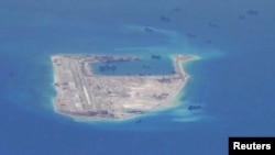 Chinese dredging vessels are purportedly seen in the waters around Fiery Cross Reef in the disputed Spratly Islands in the South China Sea in this still image taken by a P-8A Poseidon surveillance aircraft, May 21, 2015. 
