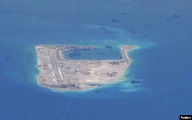 FILE - Chinese dredging vessels are purportedly seen in the waters around Fiery Cross Reef in the disputed Spratly Islands in the South China Sea in this still image taken by a P-8A Poseidon surveillance aircraft, May 21, 2015.