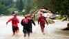 FILE - Firefighters walk through a flooded road of Jesenik, Czech Republic, Sept. 15, 2024. 