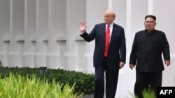 도널드 트럼프 미국 대통령과 김정은 북한 국무위원장이 지난 12일 싱가포르 카펠라 호텔에서 오찬을 마친 뒤 함께 산책로를 걷고 있다.