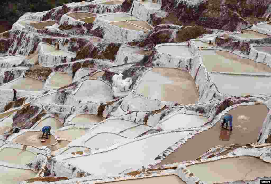 Workers collect salt from salt ponds at the Maras mines in Cuzco, Peru. Salt has been collected in Maras since pre-Incan times by evaporating highly salty local underground stream water.