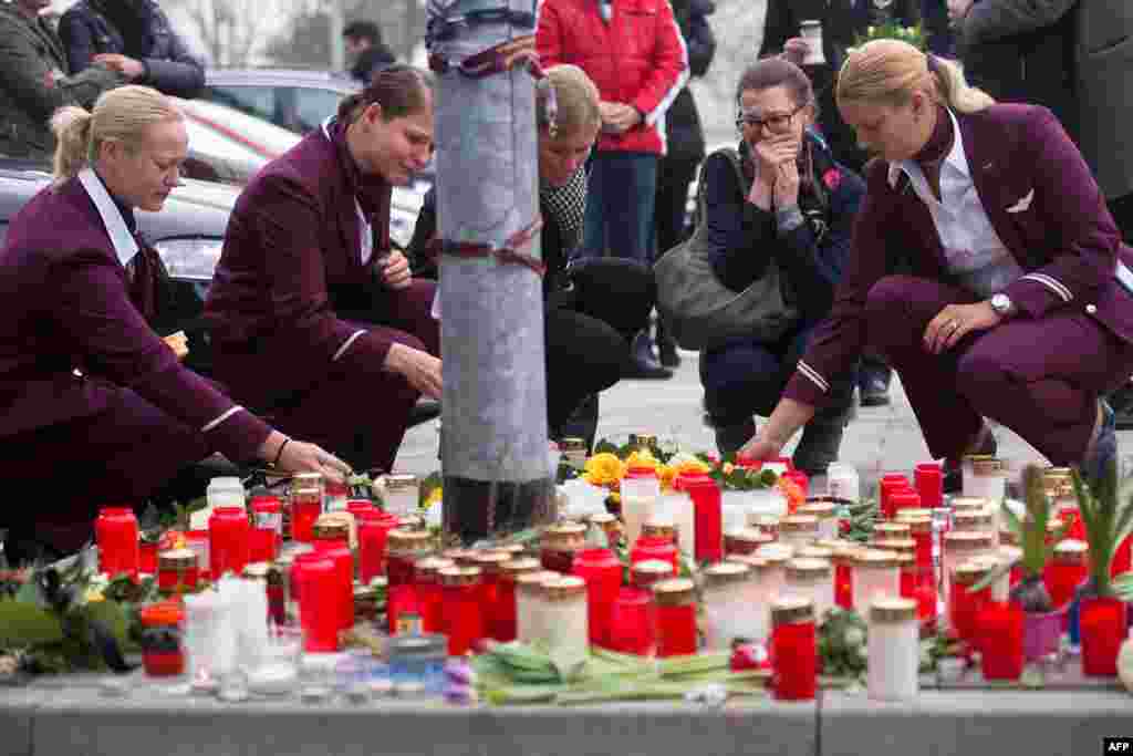 Employees of German airline Germanwings lay down candles and flowers for the victims of the plane crash in front of the company&#39;s headquarters in Cologne, western Germany. a Germanwings Airbus A320 coming from Barcelona and heading to Duesseldorf smashed into the French Alps, killing all 150 people on board.