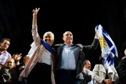 Presidential candidate for the ruling party Broad Front Daniel Martinez, right, and Graciela Villar, his running mate, wave to supporters at their headquarters in Montevideo, Uruguay, Sunday, Nov. 24, 2019.
