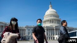 Un tour-opérateur, portant un masque de protection, dirige une tournée au Capitole américain à Washington, DC, le 9 mars 2020. (Photo: Andrew CABALLERO-REYNOLDS / AFP)