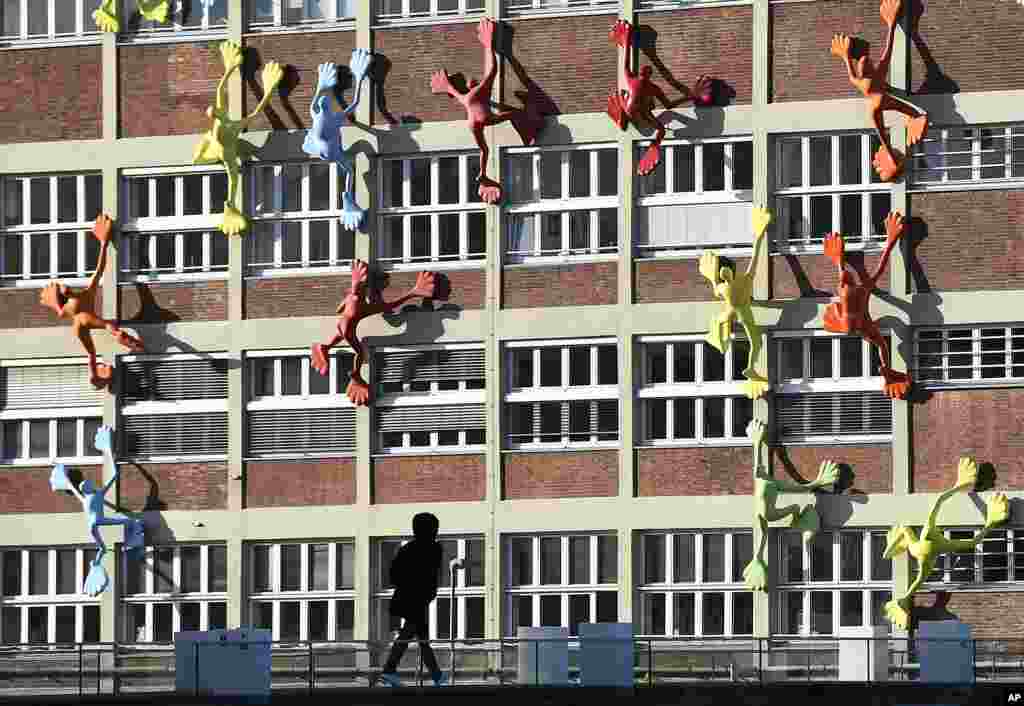 Colorful sculptures are seen climbing up a building at the harbour city in Duesseldorf, Germany.