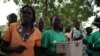 Teresa Aduong dances with other board members of the wooden box bank, Rumbek, Lakes State, South Sudan, Jan. 30, 2013. (H. McNeish/VOA)