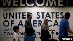 International passengers arrive at Washington Dulles International Airport after the U.S. Supreme Court granted parts of the Trump administration's emergency request to put its travel ban into effect.