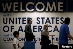 International passengers arrive at Washington Dulles International Airport after the U.S. Supreme Court granted parts of the Trump administration's emergency request to put its travel ban into effect later in the week pending further judicial review, in D