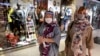 Women wearing protective face masks and gloves to help prevent the spread of the coronavirus shop at the Kourosh Shopping Center in Tehran, Iran, Monday, April 20, 2020. 