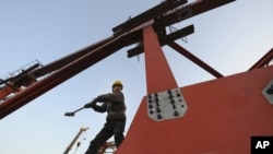 A laborer works at a high-speed railway viaduct construction site in Hefei, Anhui province, China, Jan. 4, 2011.