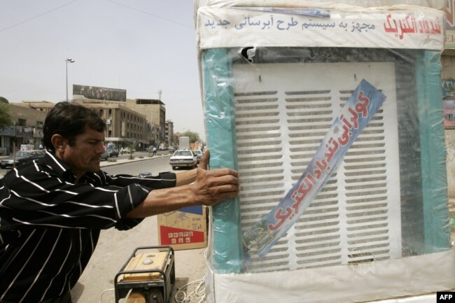 FILE - An Iraqi merchant receives a delivery of Iranian-made air coolers, at his shop in central Baghdad.