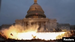 An explosion caused by a police munition is seen while supporters of U.S. President Donald Trump gather in front of the Capitol Building in Washington, Jan. 6, 2021.