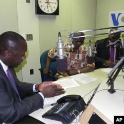 Liberia Planning Minister Amara Konneh (foreground) and Finance Minister Augustine Ngafuan being interviewed by James Butty (center)