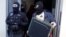 FILE - German special police leave a house in Berlin Nov. 15, 2016. German police launched dawn raids on mosques, apartments and offices in 10 German states, and the government banned a group it accused of trying to recruit fighters for Islamic State, the interior ministry said.