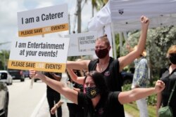 Jennifer Degroff, owner of the Tipsy Rose Bar and Catering Services, protests in support of the live events industry receiving federal aid outside of the office of Sen. Marco Rubio, R-Fla., during the coronavirus pandemic, July 30, 2020, in Miami.