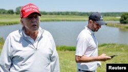 El expresidente de Estados Unidos, Donald Trump (izq.), habla con los reporteros mientras él y su hijo Eric Trump participan en el torneo Pro-Am antes del LIV Golf Invitational en el Trump National Golf Club en Sterling, Virginia, EEUU., el 25 de mayo de 2023.