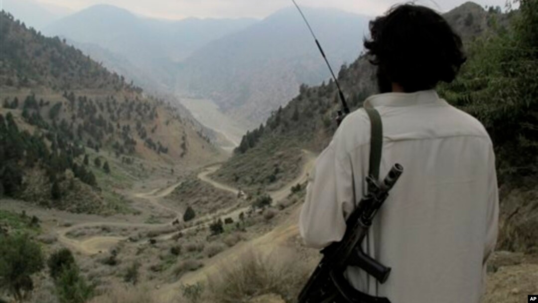 Seorang militan Taliban Pakistan melihat ke arah jalan utama Shawal di Waziristan Utara, Pakistan (10/8/2013). Militan Taliban di Pakistan dilaporkan berlatih di negara itu untuk menghadapi perang etnis jika tentara asing ditarik dari Afghanistan akhir 2014.