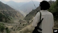 Seorang militan Taliban Pakistan melihat ke arah jalan utama Shawal di Waziristan Utara, Pakistan (10/8/2013). Militan Taliban di Pakistan dilaporkan berlatih di negara itu untuk menghadapi perang etnis jika tentara asing ditarik dari Afghanistan akhir 2014.