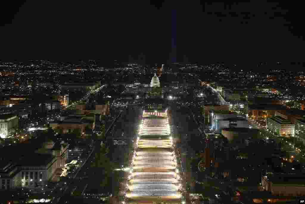 The U.S. Capitol building is prepared for the inauguration ceremonies for President-elect Joe Biden as the &quot;Field of Flags&quot; are illuminated on the grounds on the National Mall, Jan. 18, 2021. in Washington.