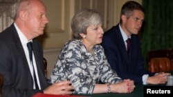 FILE - British Prime Minister Theresa May, center, sits with Gavin Williamson, her new defense secretary, left, and Britain's First Secretary of State Damian Green inside 10 Downing Street, London, June 26, 2017.