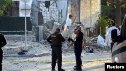 Police officers stand guard near the site of a bomb attack at a police station in Barranquilla, Colombia Jan. 28, 2018. 