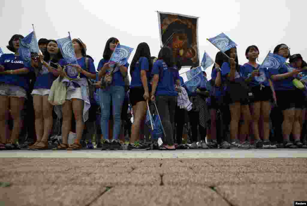 Catholic faithful wait for arrival of Pope Francis for a private mass outside the Apostolic Nunciature in Seoul, August 14, 2014.