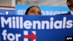 A 'millennial' supporter looks on as Democratic presidential nominee former Secretary of State Hillary Clinton speaks during a campaign rally in Coral Springs, Florida, Sept. 30, 2016. 