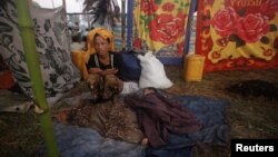 A woman displaced by the recent violence in Pauktaw sits by her sleeping child at Owntaw refugee camp for Muslims outside Sittwe, Burma, November 1, 2012.