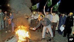 Pakistani protesters burn tires during a demonstration in Lahore, Pakistan, against the release of Raymond Allen Davis, an American CIA contractor, March 16, 2011
