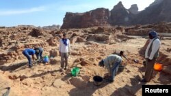 A French archaeologist and his co-workers carefully clean the pottery to examine the findings known to be from Dadan and Lihyan civilization dated back to the second half of the first millennium BC, in Al-Ula, Saudi Arabia October 30, 2021. (REUTERS/Ahmed Yosri)