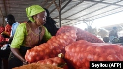 Une vendeuse d'oignons trie des sacs d'oignons au marché de Notto Gouye Diama, l'un des principaux marchés de produits agricoles de la région de Thiès, le 17 juillet 2021.