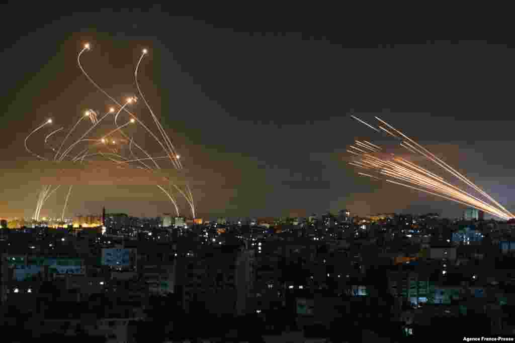 The Israeli Iron Dome missile defense system (L) intercepts rockets (R) fired by the Hamas movement towards southern Israel from Beit Lahia in the northern Gaza Strip as seen in the sky above the Gaza Strip overnight, May 14, 2021.&nbsp;Israel bombarded Gaza with artillery and airstrikes in response to a new barrage of rocket fire from the Hamas-run enclave, claiming more than 100 Palestinian lives.
