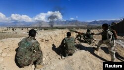 FILE - Afghan security forces take position during a gun battle between Taliban and Afghan security forces in Laghman province, Afghanistan, March 1, 2017.