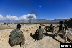 FILE - Afghan security forces take position during a gun battle between Taliban and Afghan security forces in Laghman province, Afghanistan, March 1, 2017.