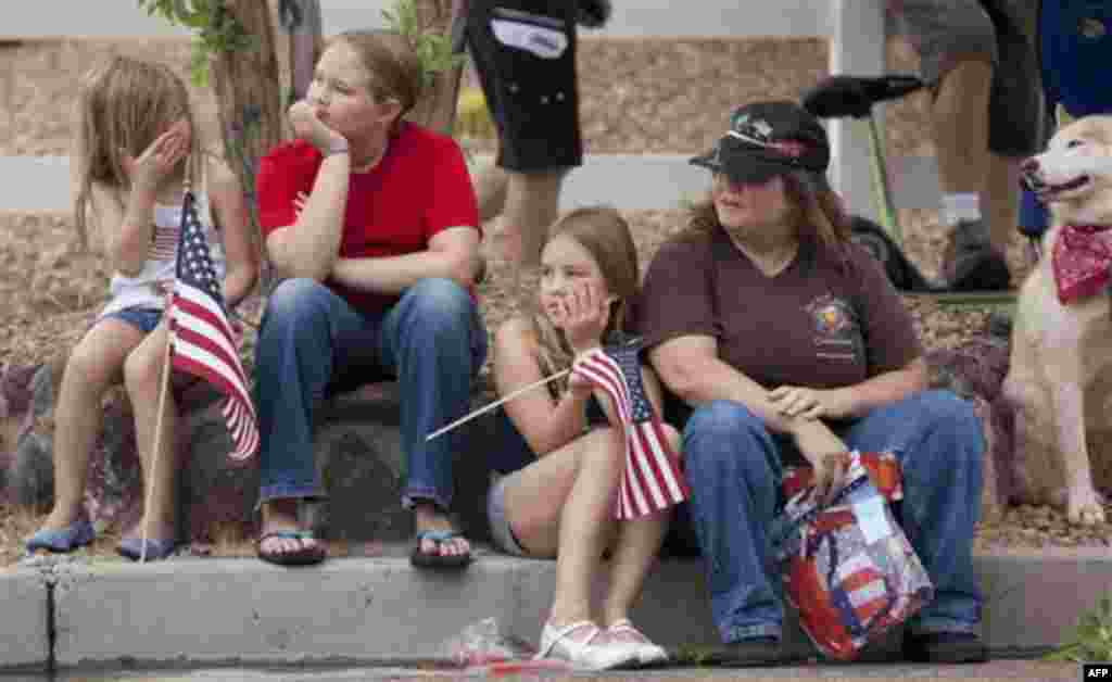 A family watches as floats and other entrees roll by during the 63rd Annual Boulder City Damboree Parade, Monday, July 4, 2011, in Boulder City, Nev. (AP Photo/Julie Jacobson)