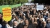 Worshippers chant slogans against America, Israel and Saudi Arabia, as one of them holds up an anti-American placard, in a rally to condemn the Sept. 22, 2018 terror attack in Ahvaz, after prayers in Tehran, Iran, Sept. 28, 2018.