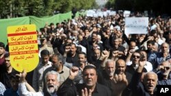 Worshippers chant slogans against America, Israel and Saudi Arabia, as one of them holds up an anti-American placard, in a rally to condemn the Sept. 22, 2018 terror attack in Ahvaz, after prayers in Tehran, Iran, Sept. 28, 2018.